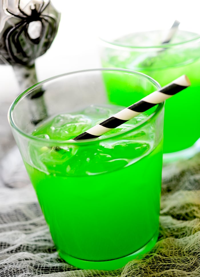 Witch's Brew Cocktail in a spooky spider glass with a straw.