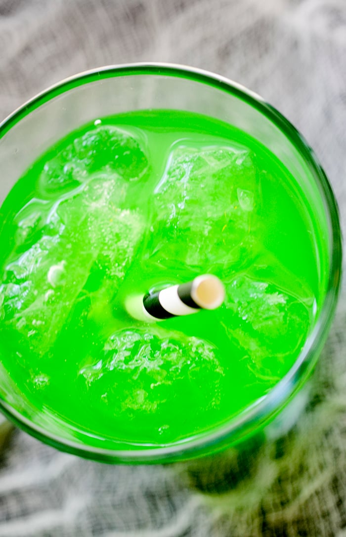 Witch's Brew Cocktail in a spooky spider glass with a straw.