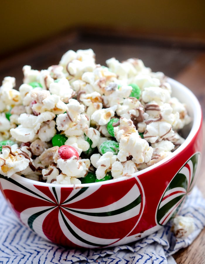 Christmas Crunch Popcorn - Christmas Crunch Popcorn is packed with peanuts, red and green M&M candies, and almond bark. The perfect gift giving snack to bring for someone around the Holidays. 