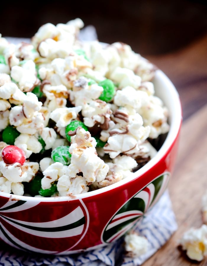 Christmas Crunch Popcorn - Christmas Crunch Popcorn is packed with peanuts, red and green M&M candies, and almond bark. The perfect gift giving snack to bring for someone around the Holidays. 