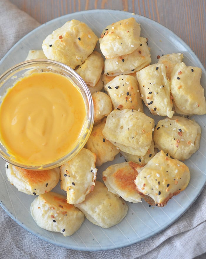 2 ingredient pretzel dough bites with a cup of cheese sauce 