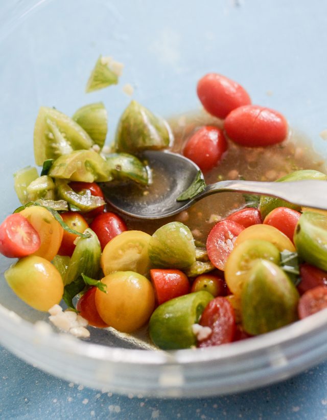 Bowl of fresh tomatoes with a spoon. 