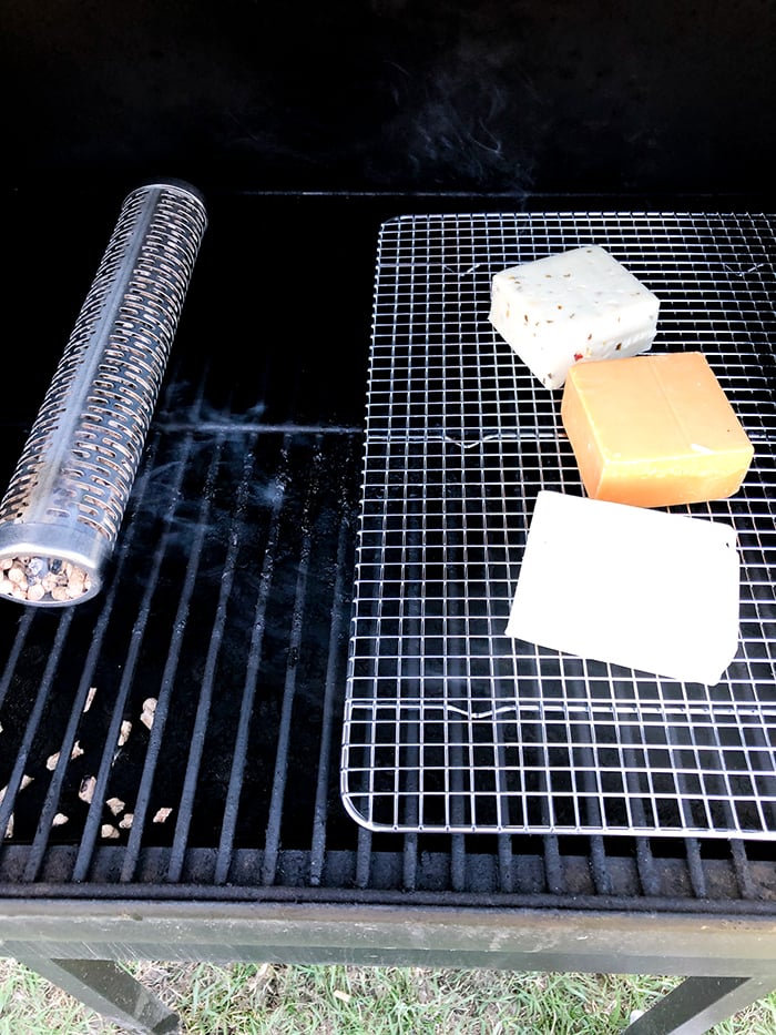 different types of smoked cheese on a smoker with a smoke tube