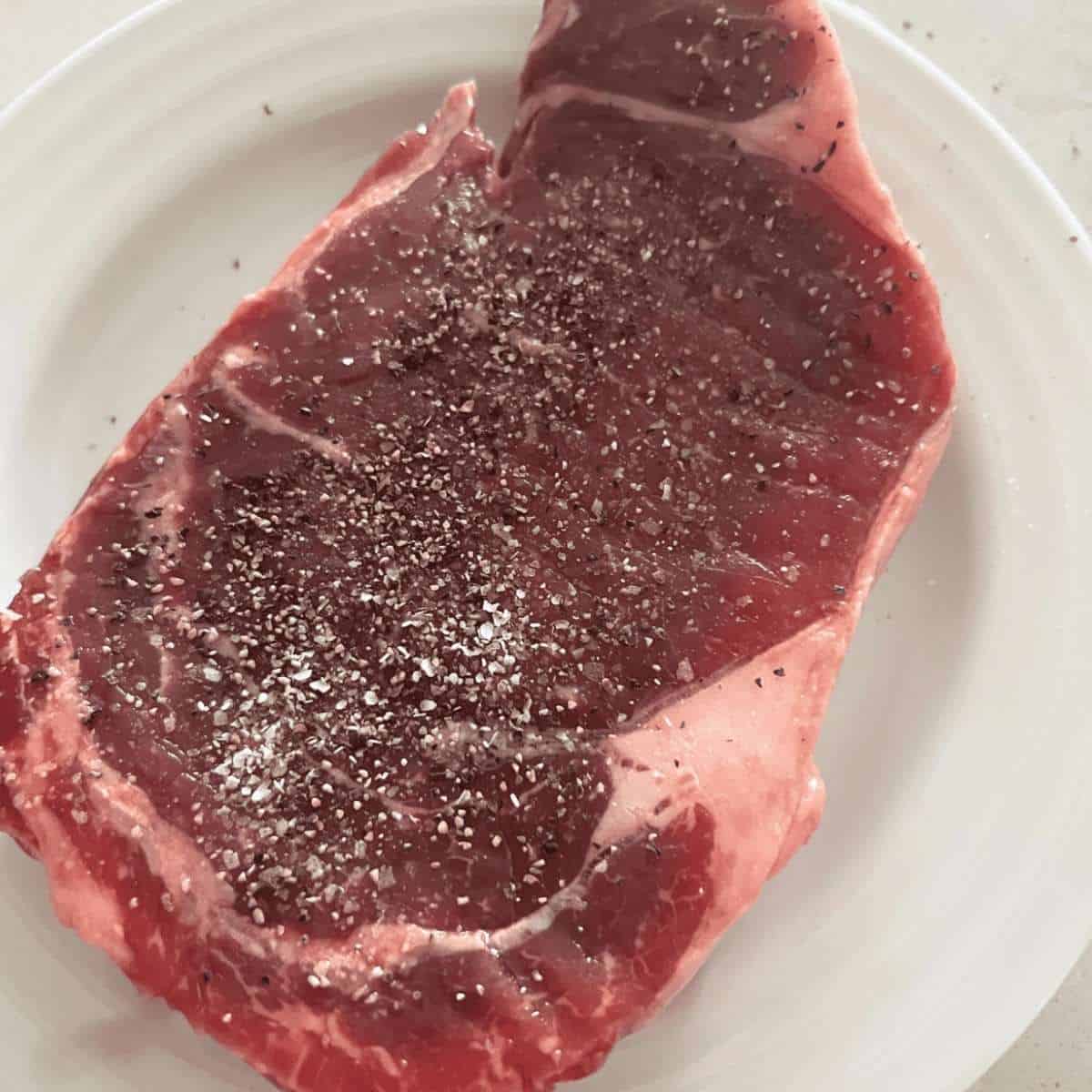 Seasoned air fryer steak with salt and pepper. 