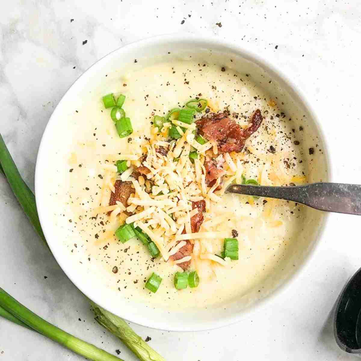 Paula Deen's Potato soup recipe topped with cheese and bacon. 