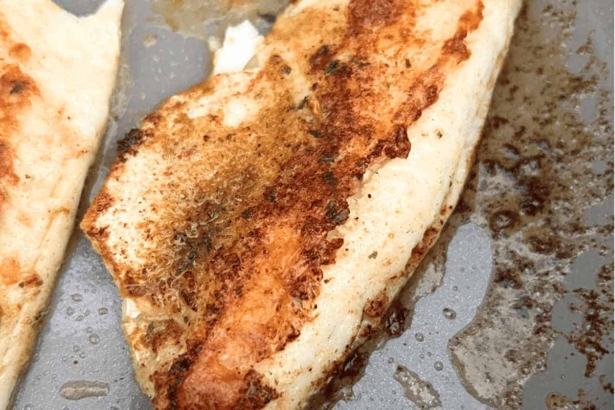 Golden crispy pan seared walleye in a skillet. 