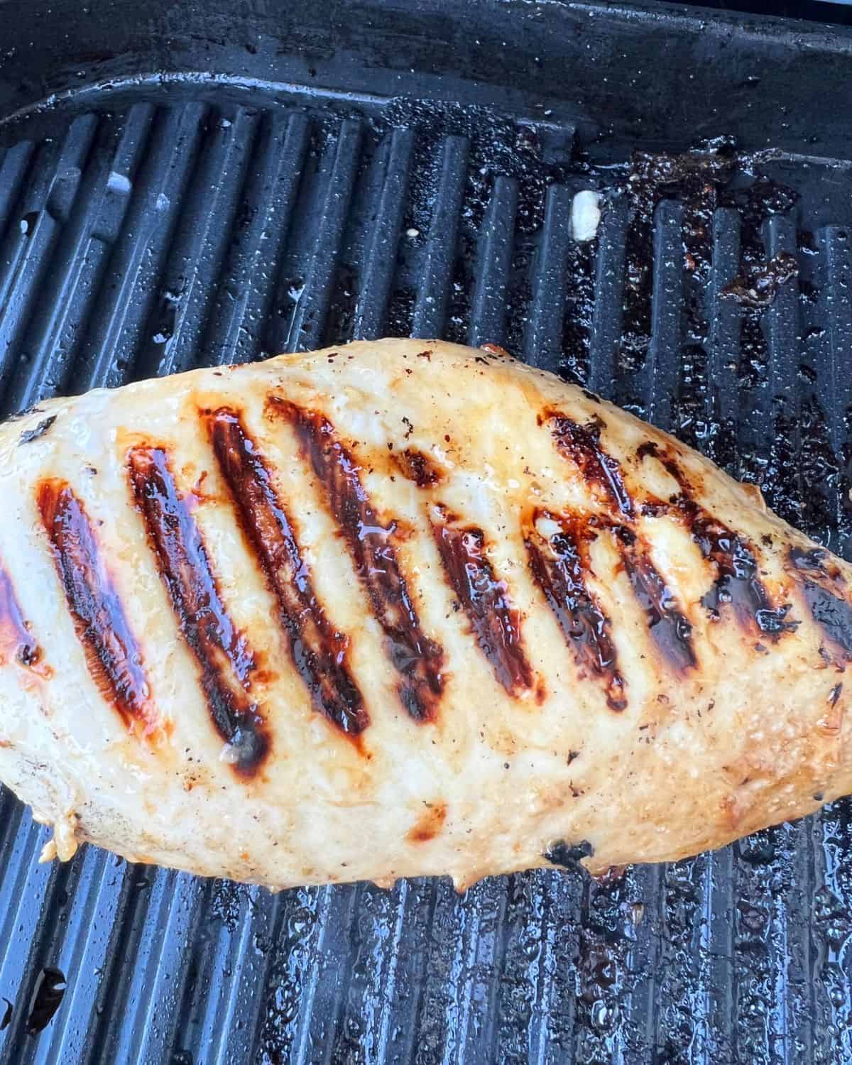 Grilled chicken breasts marinaded in 3 ingredients on a grill. 