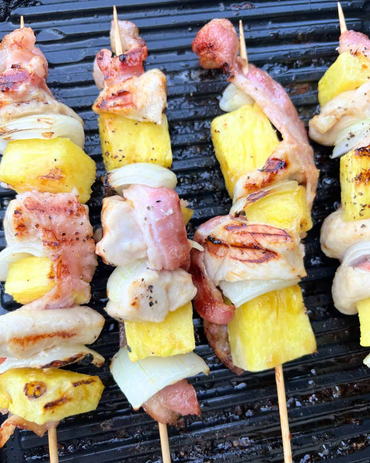 Grilled bacon, pineapple, and chicken skewers ready for serving. 