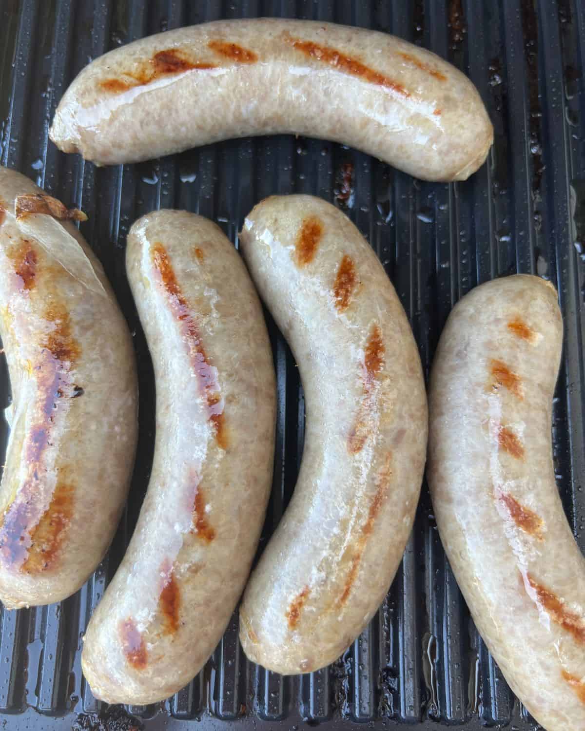 Perfectly cooked beer brats on a grill. 