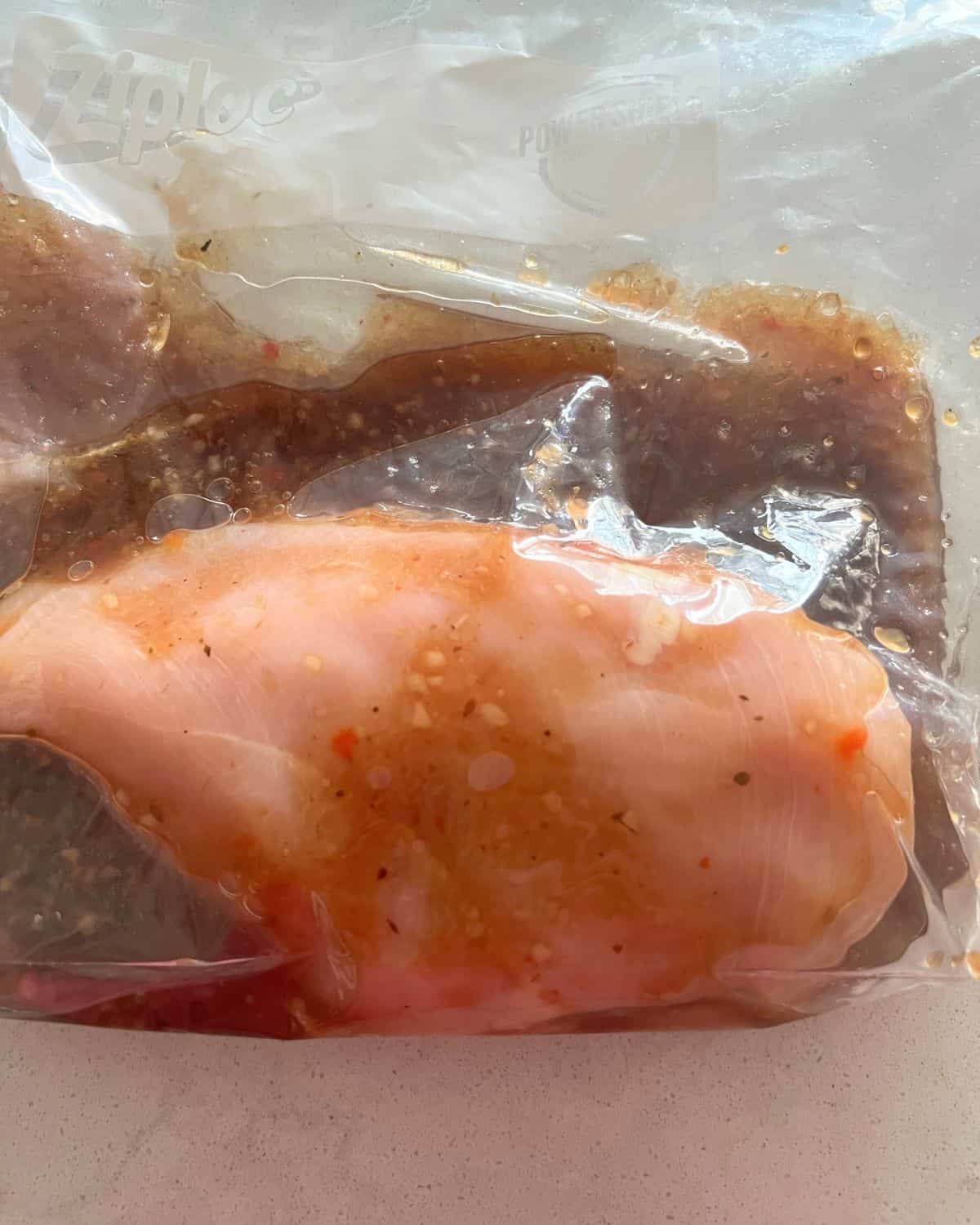 Grilled marinade for chicken in a freezer storage bag with chicken. 
