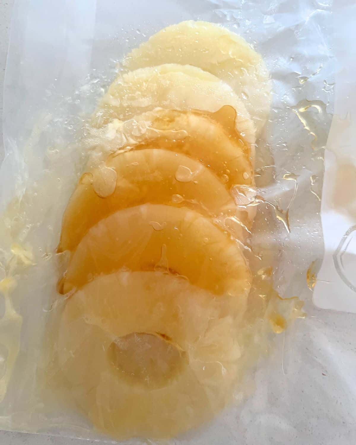 Marinaded grilled pineapple in a ziplock bag.