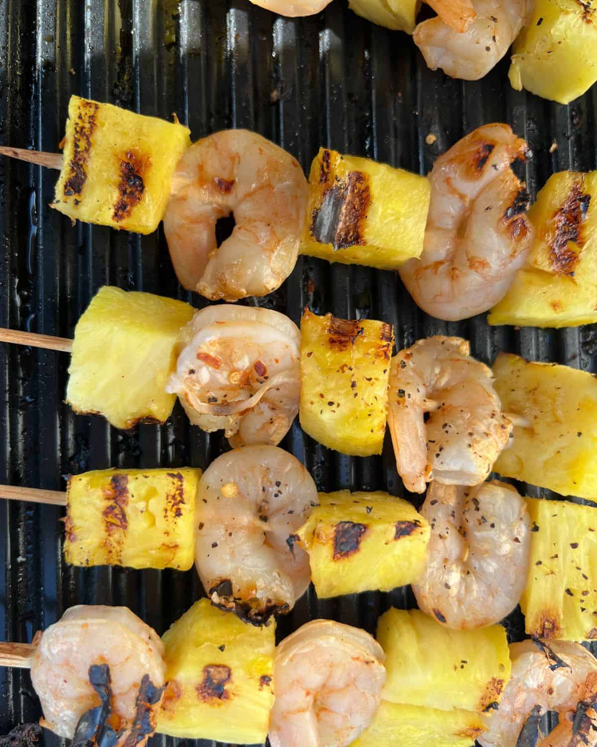 Grilled shrimp and pineapple kabobs finished on the grill. 