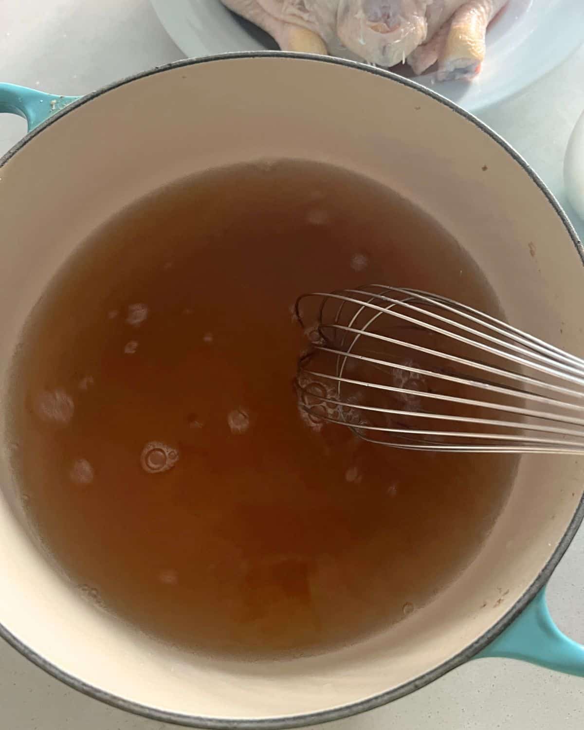 Brown sugar, salt, and water being whisked in a pot for the chicken. 
