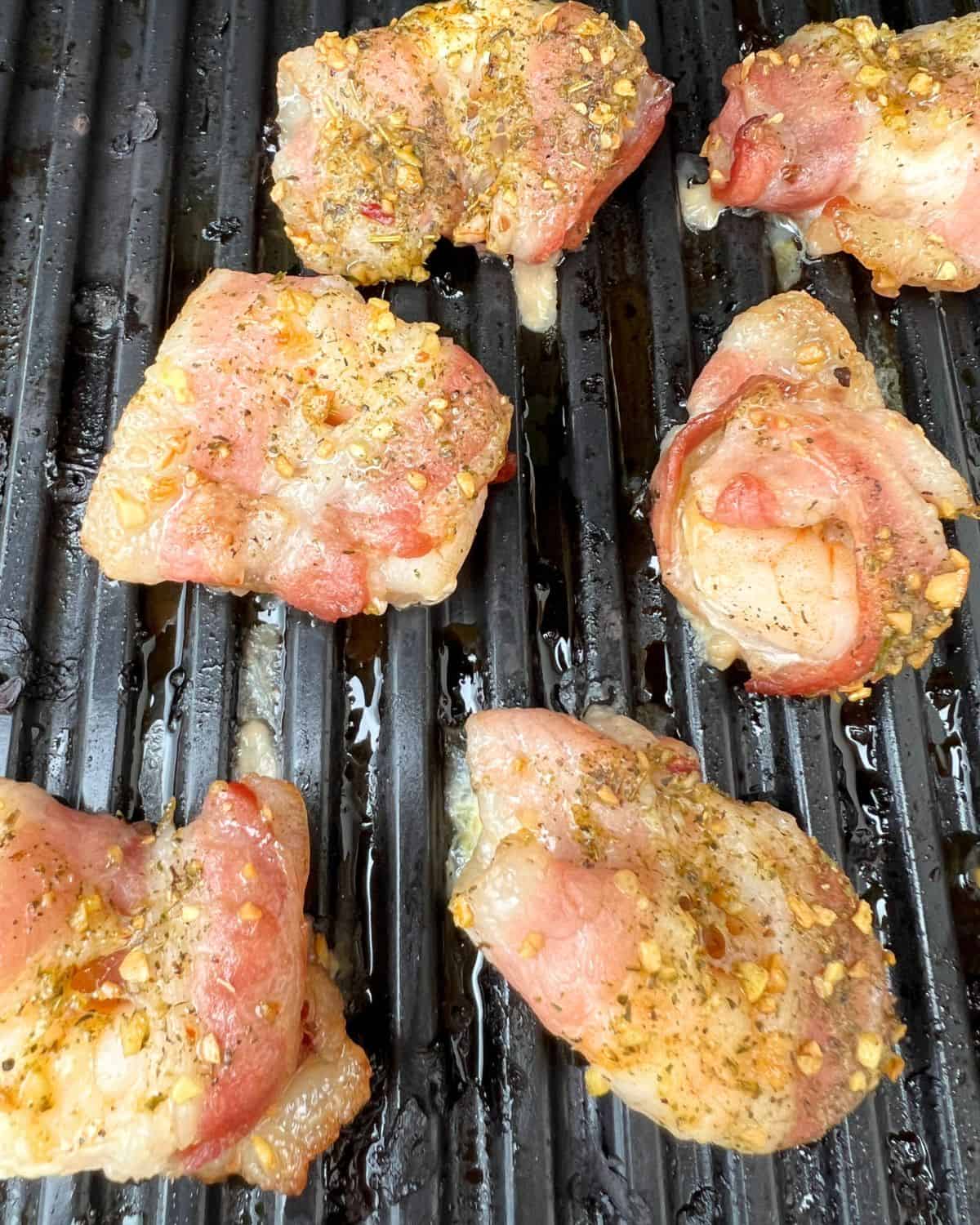 Smoked seasoned Shrimp wrapped in bacon on a smoker. 