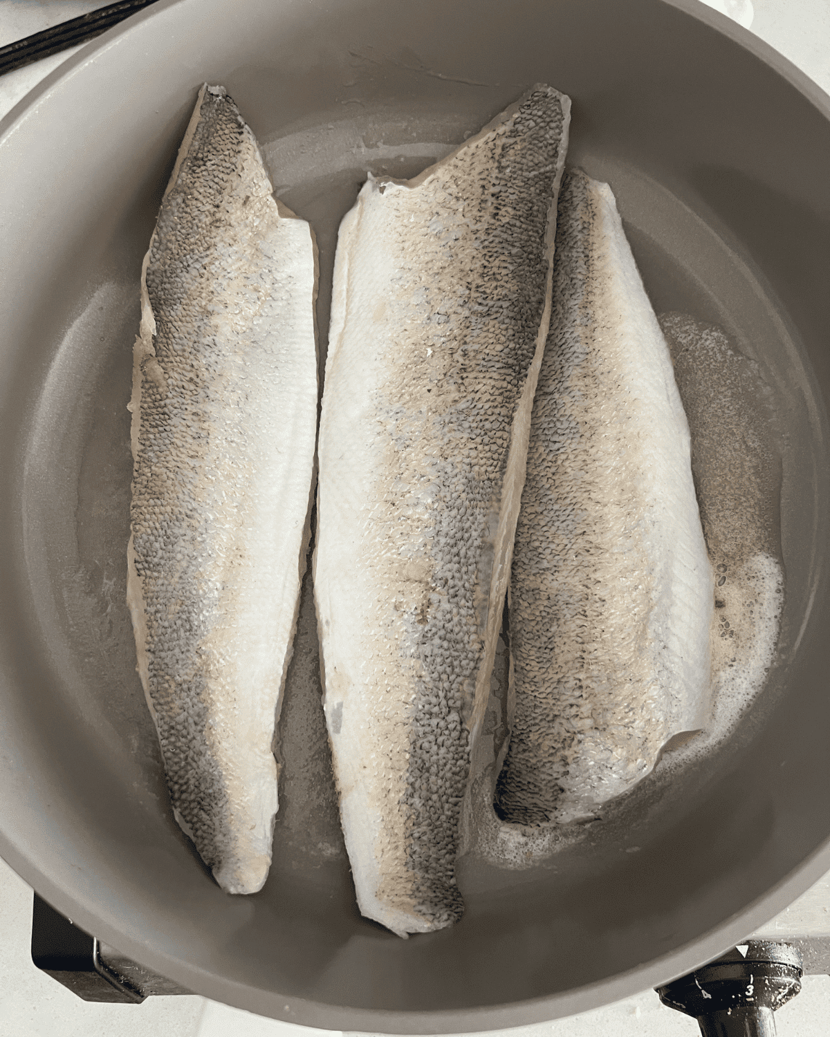 walleye cooking over butter in a skillet