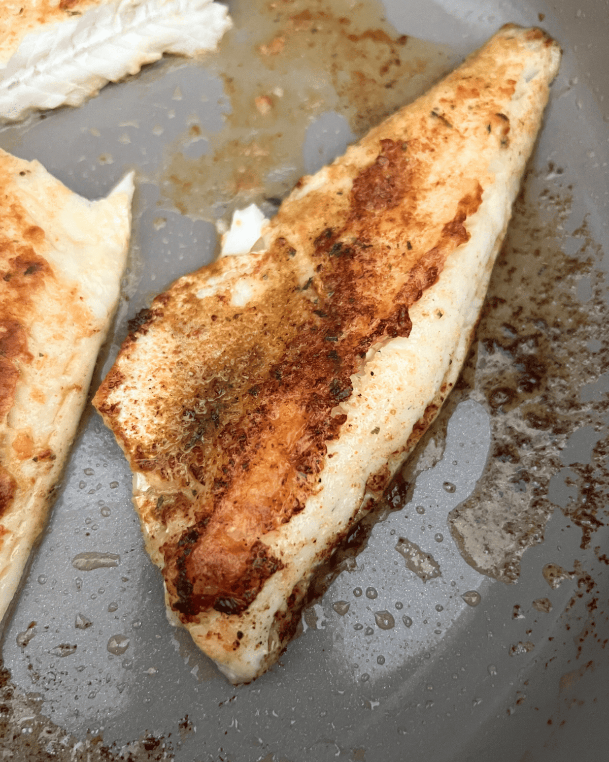 finished seasoned walleye that has been cooked to proper temperature on a skillet.