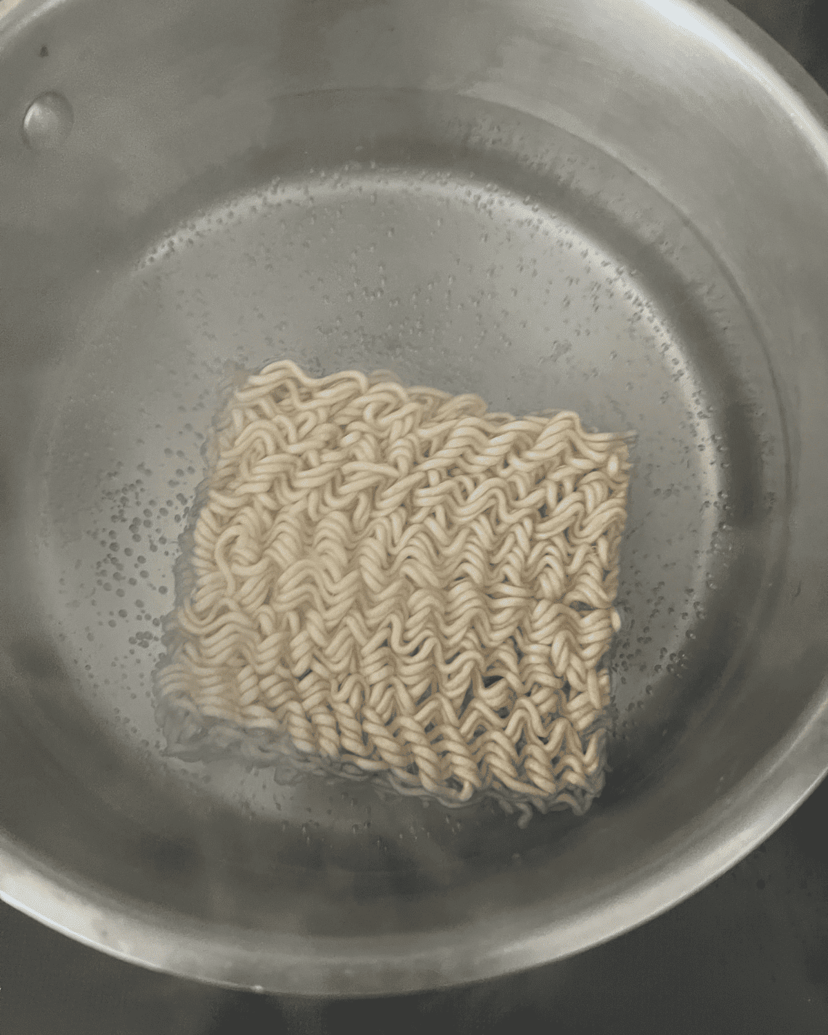 cooked ramen noodles boiling in a pan 