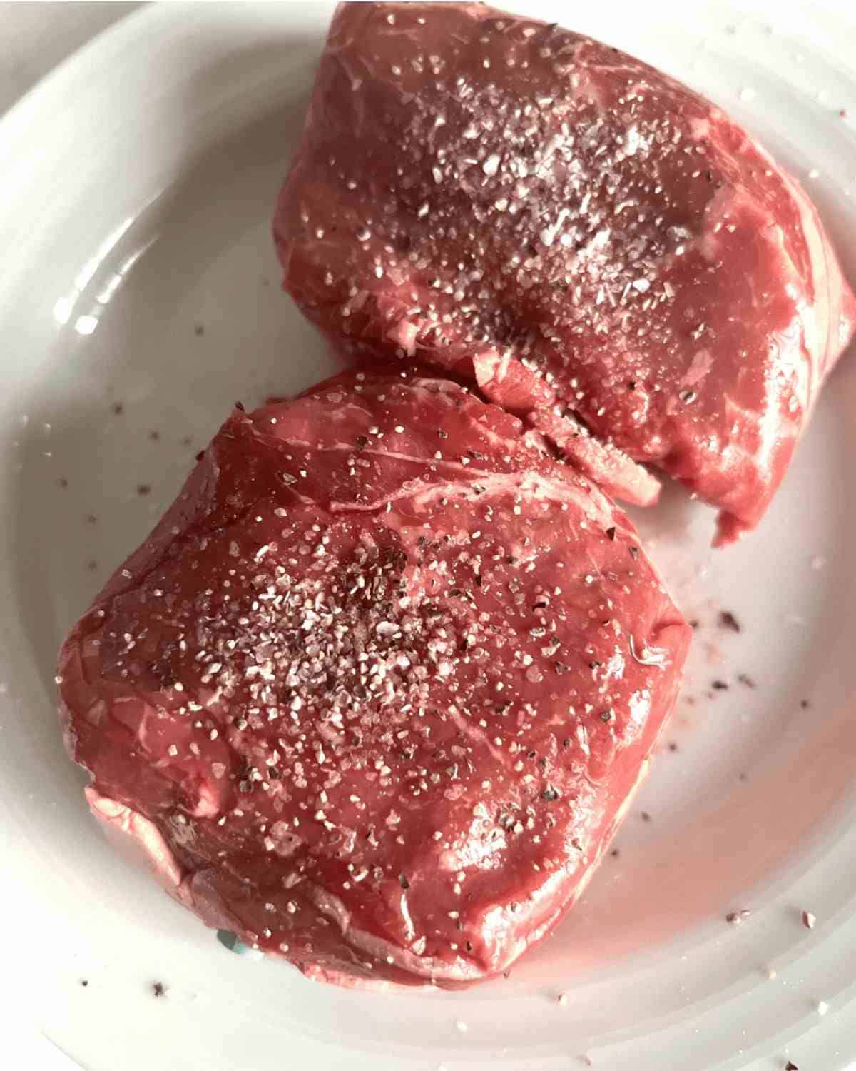 Top sirloin steak seasoned with salt and pepper. 