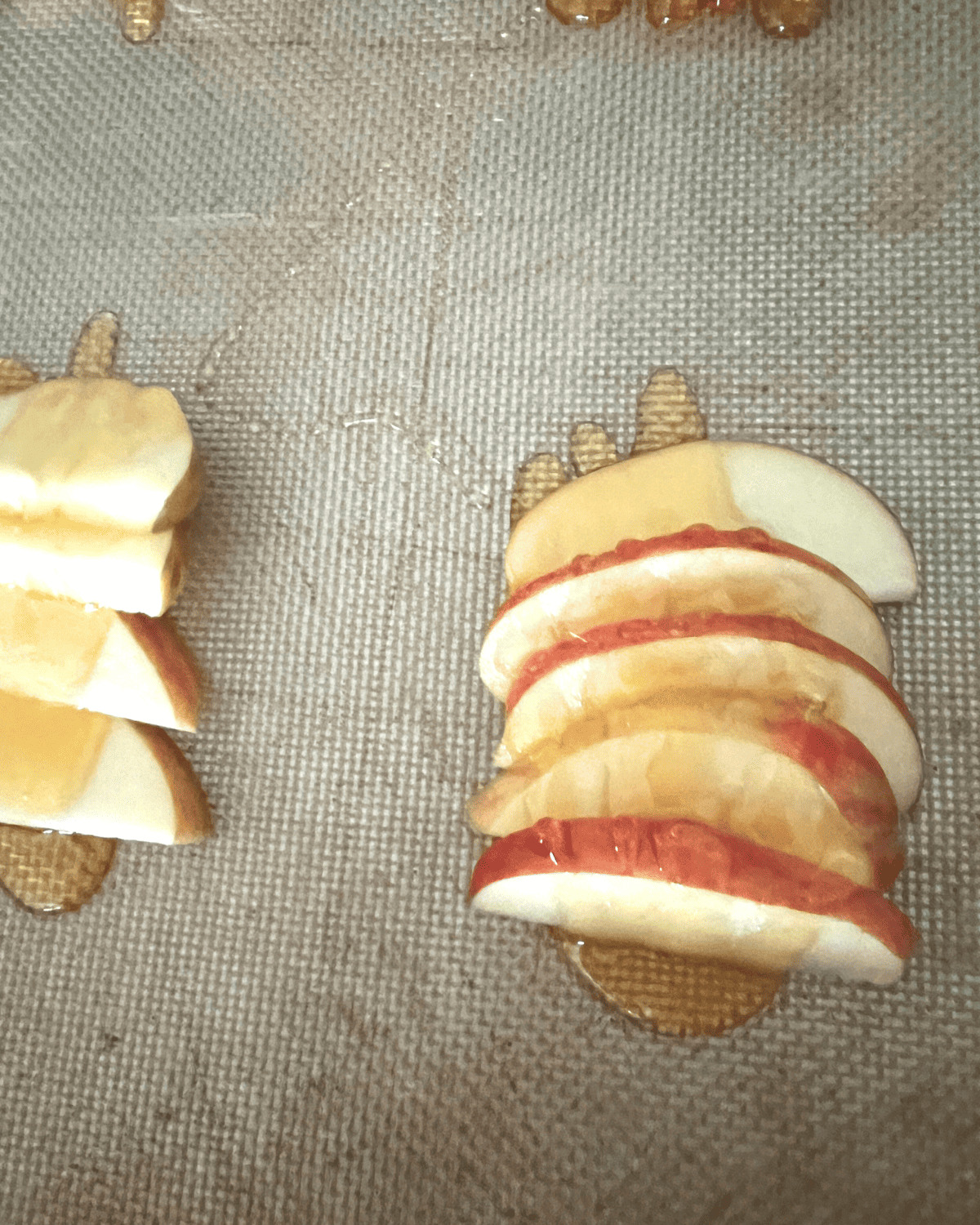 Honey drizzled on top of sliced apples on a baking sheet. 
