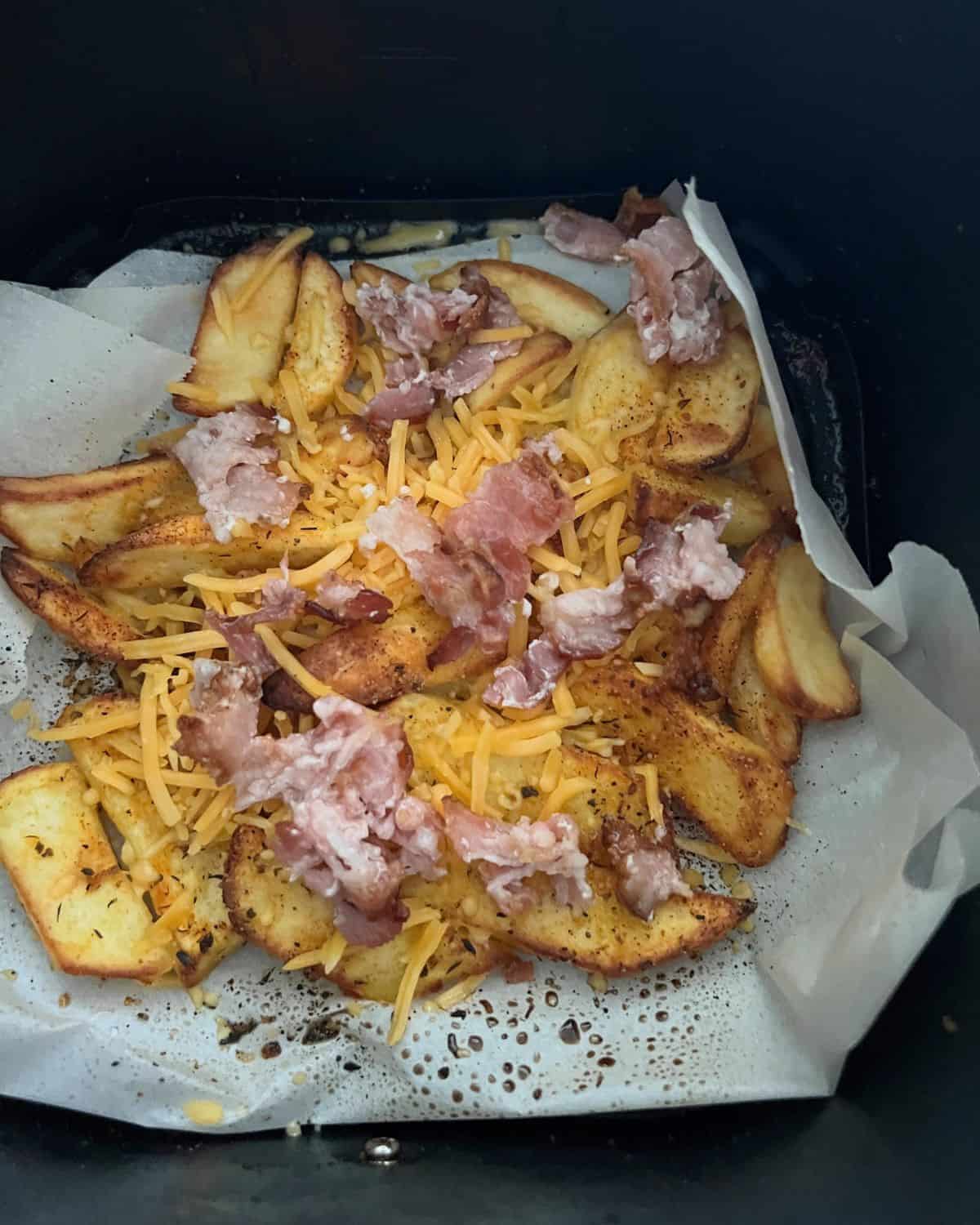 Air fryer french fries topped with cheddar and bacon. 