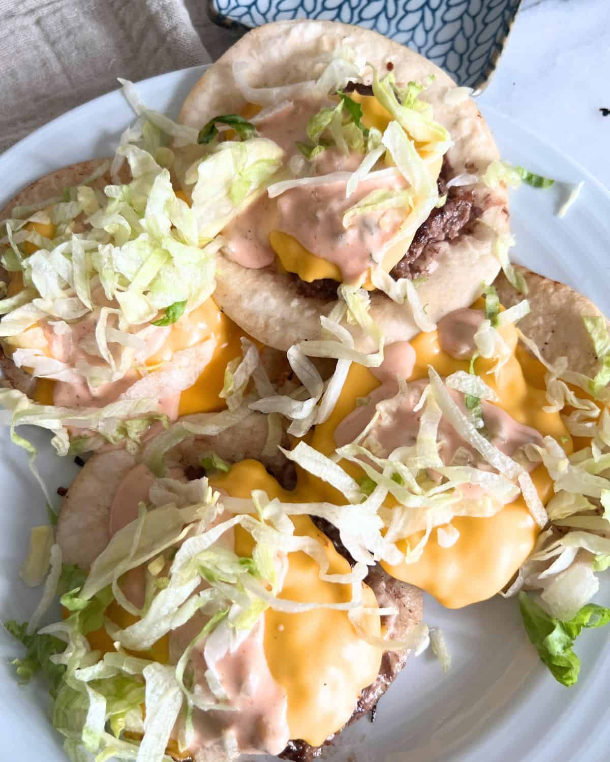 Assembled big mac tacos with lettuce and cheese. 
