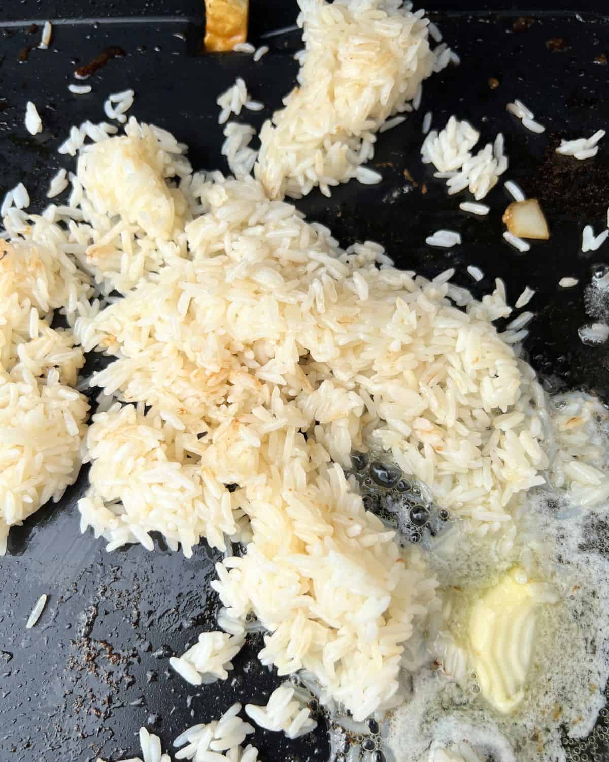 Rice and butter cooking on a Blackstone. 