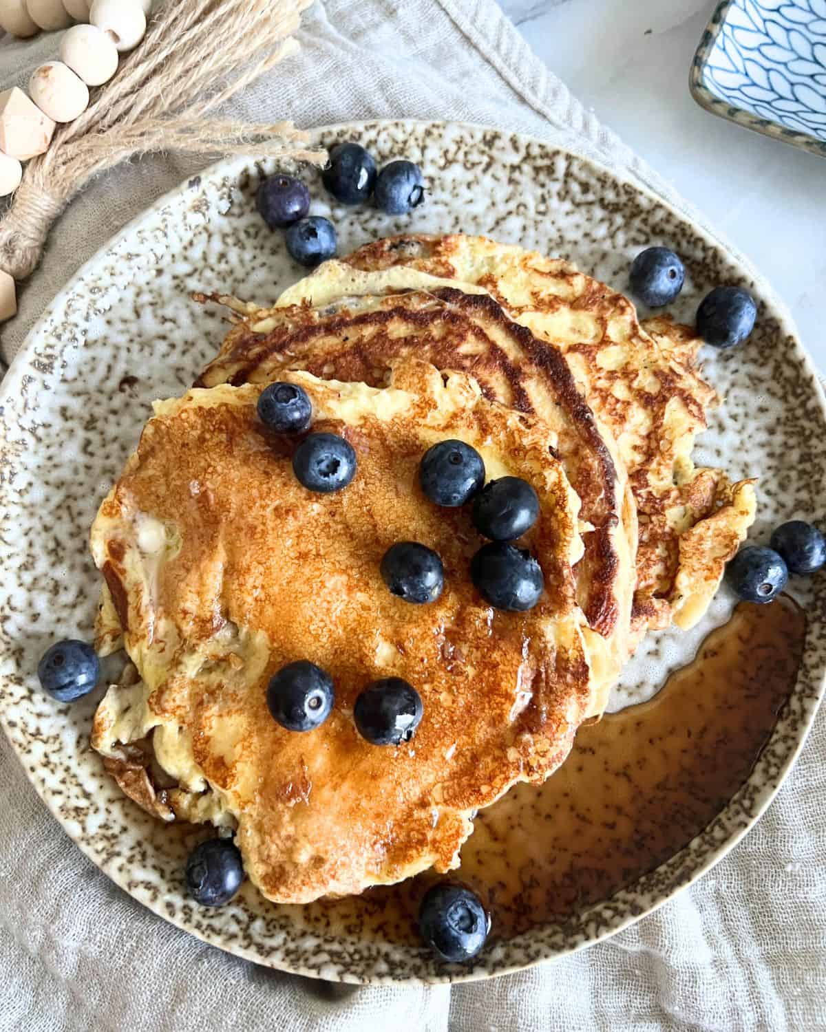 Blackstone Pancakes on a plate with maple syrup and blueberries. 