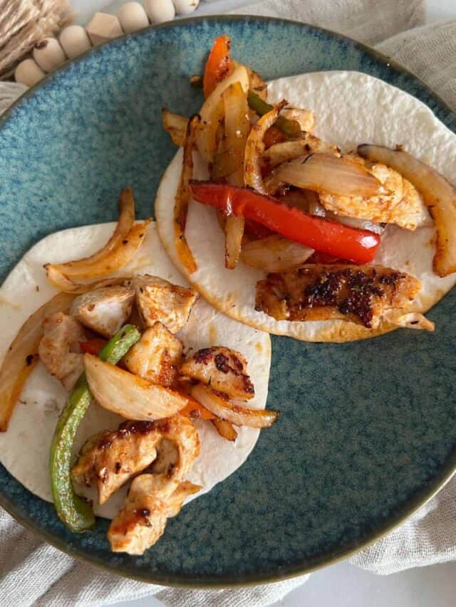 Blackstone chicken fajitas on a blue plate.