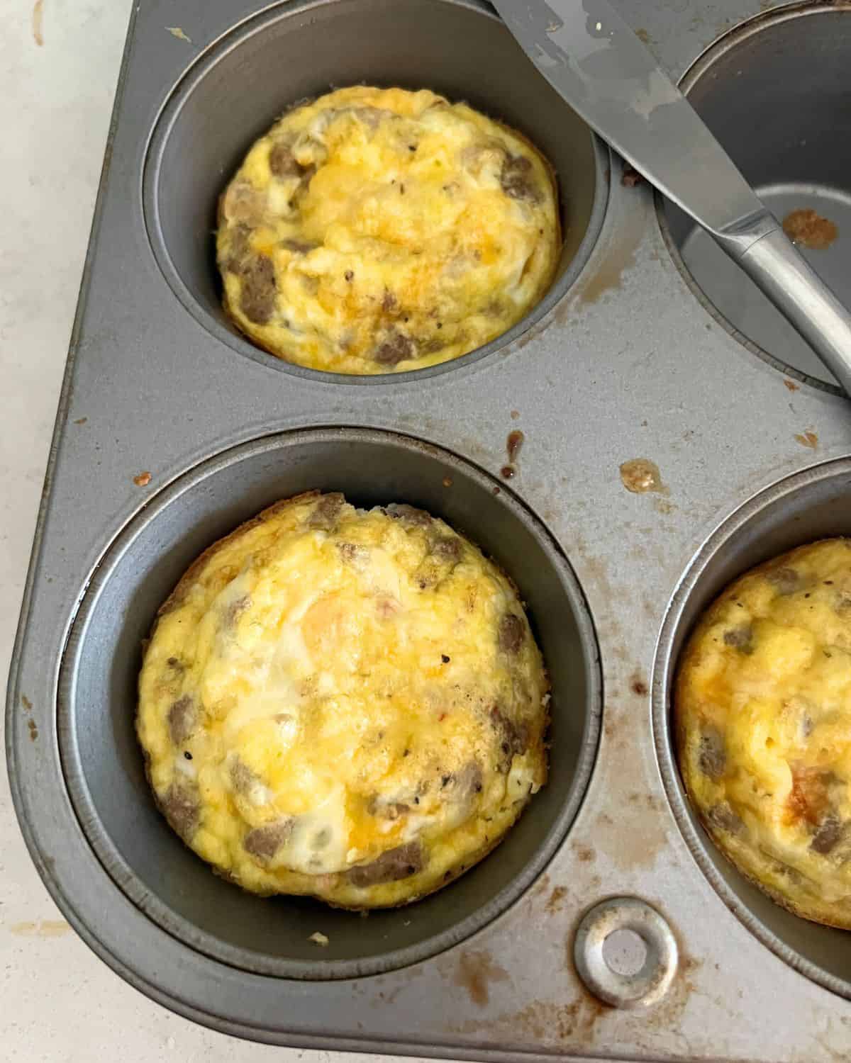 Egg and sausage muffins cooked in a muffin pan. 