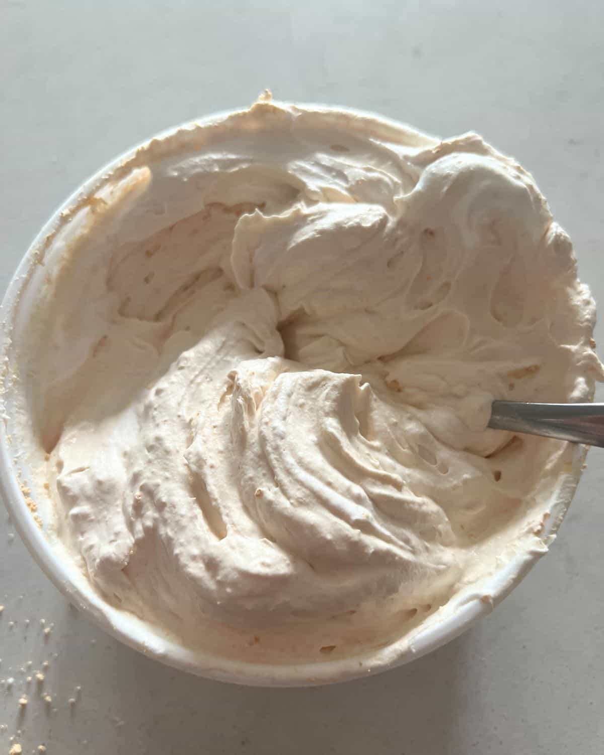 Cool whip and peanut butter powder mixed in a bowl. 