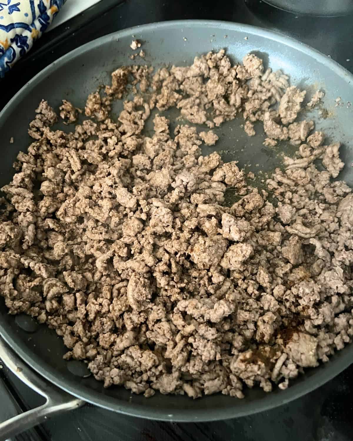 Ground taco beef cooking in a skillet. 