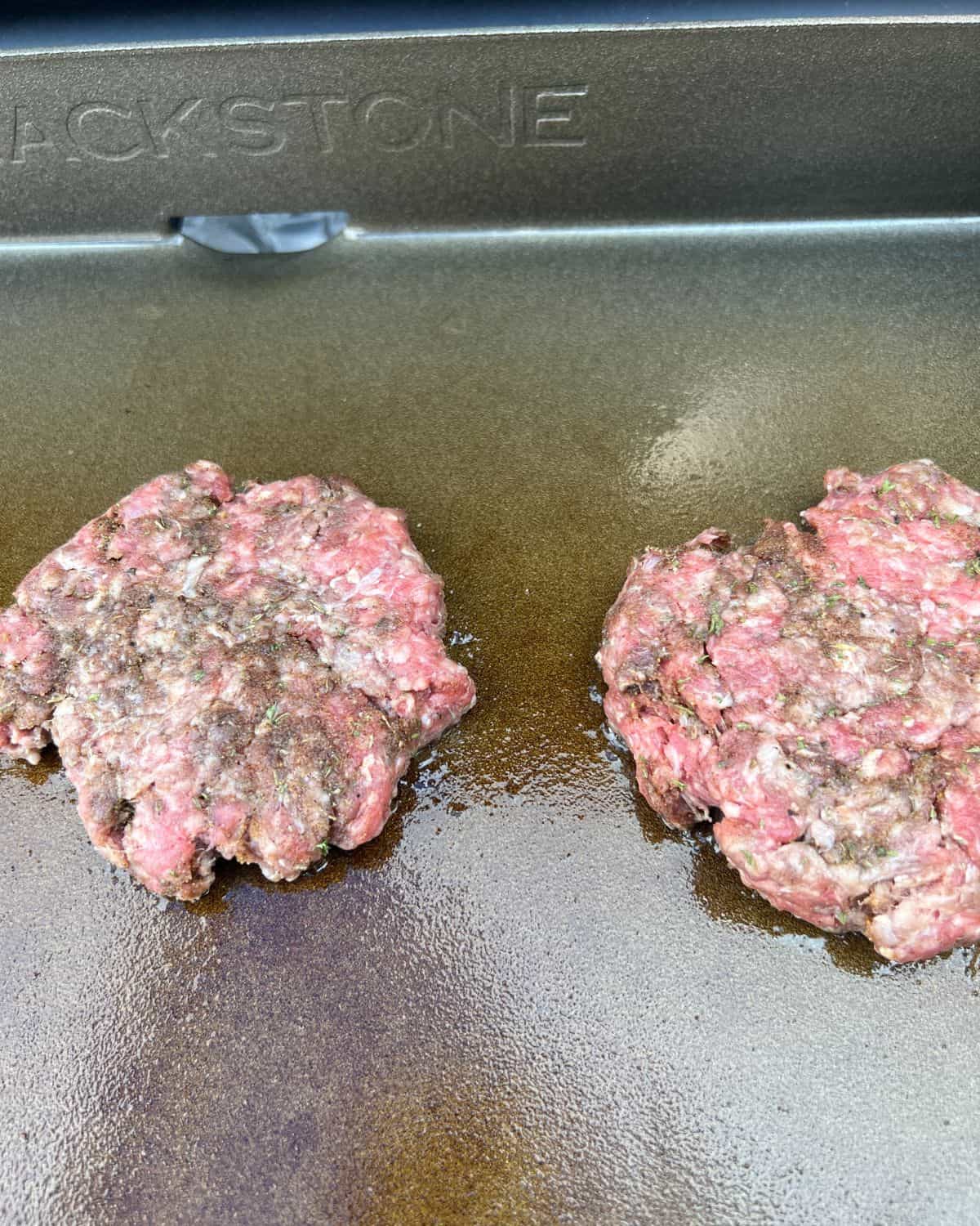 Jerk burgers cooking on a grill.