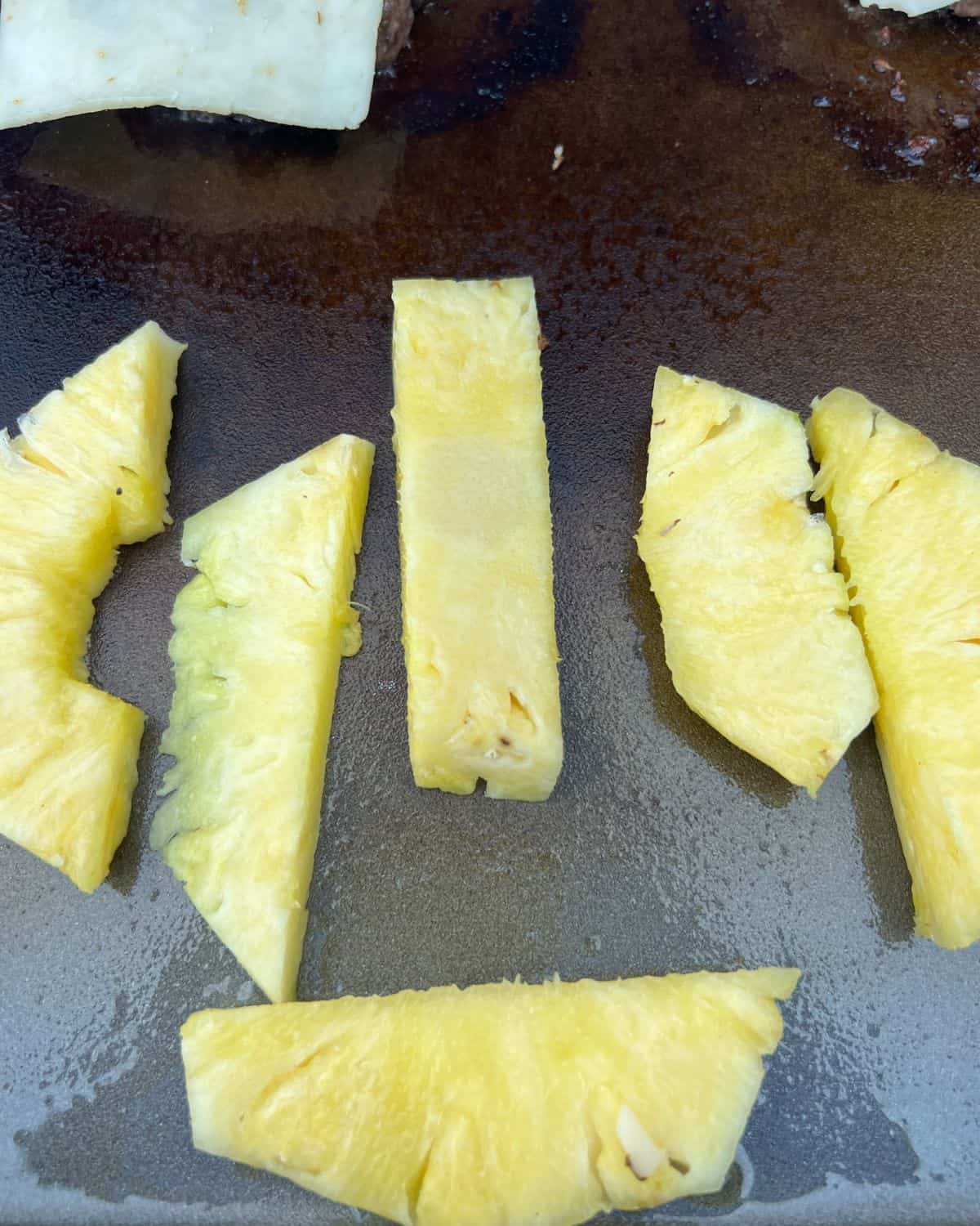 Grilled pineapple slices on a Blackstone. 