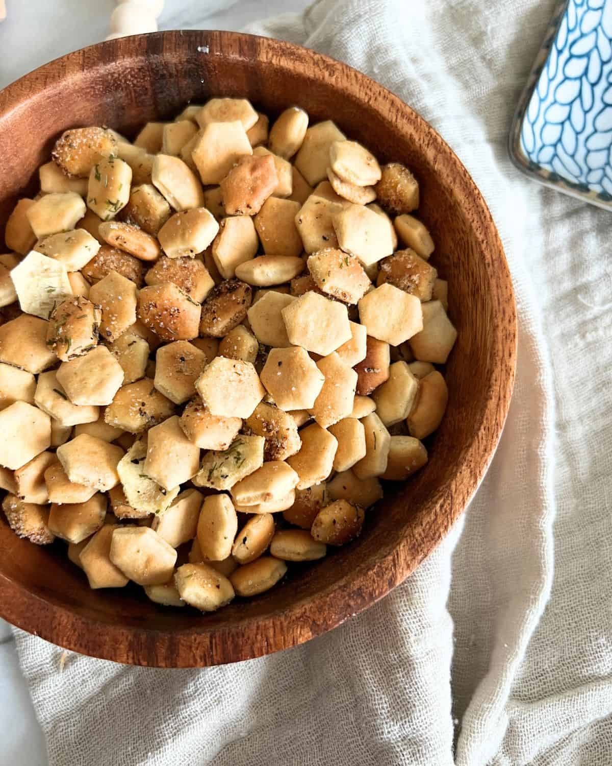 Seasoned air fried oyster crackers in a wooden bowl. 