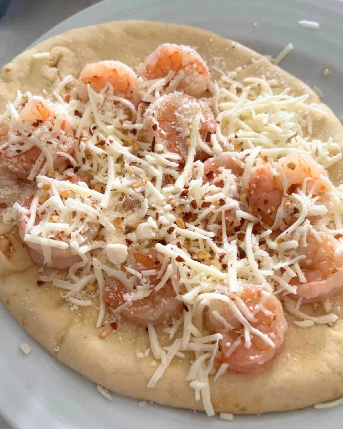 Shrimp scampi pizza topped with cheese and parmesan. 
