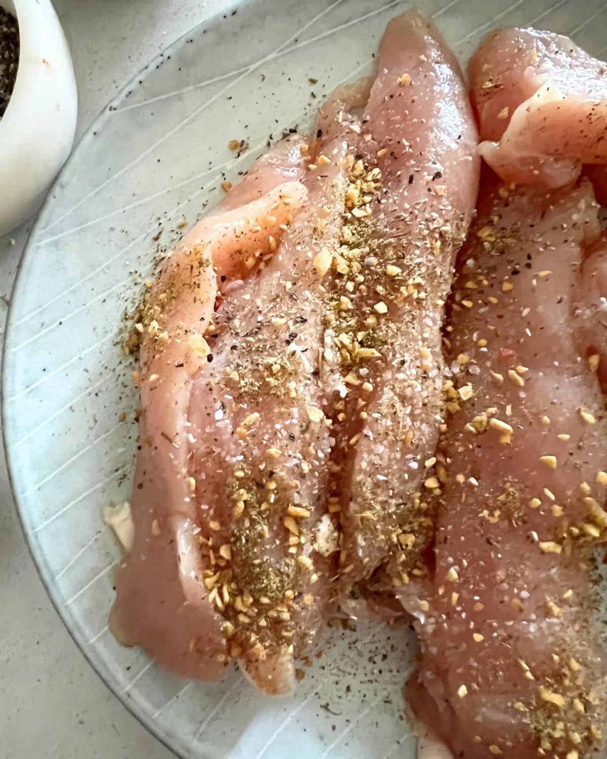 Seasoned smoked chicken tenders on on a blue plate. 