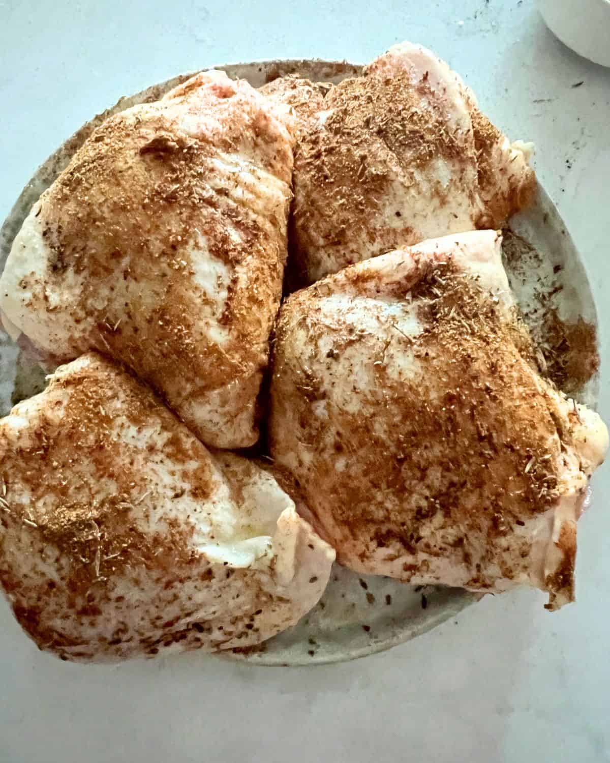 Seasoned chicken thighs rubbed with olive oil. 