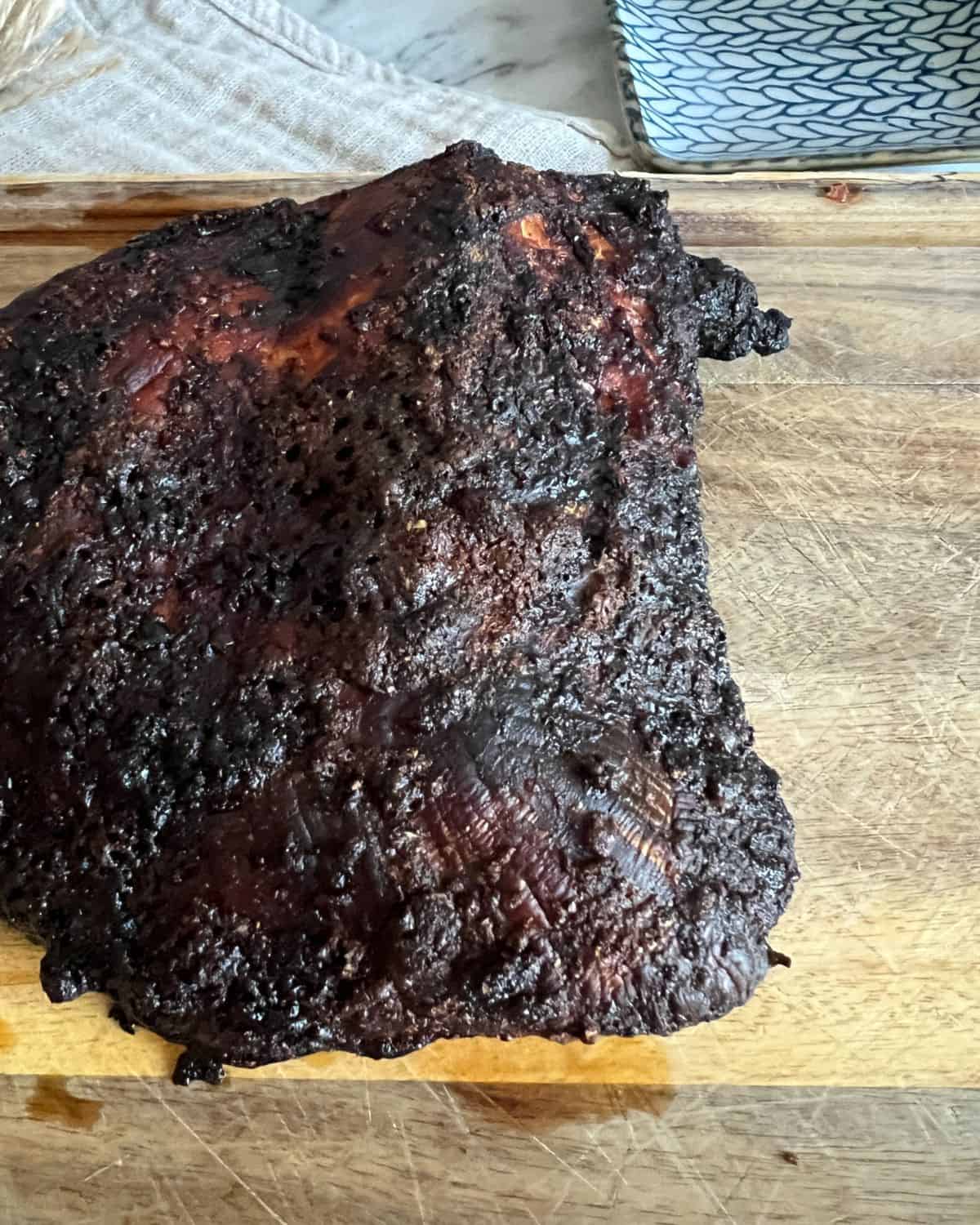 Finished smoked turkey breast on a wooden cutting board. 