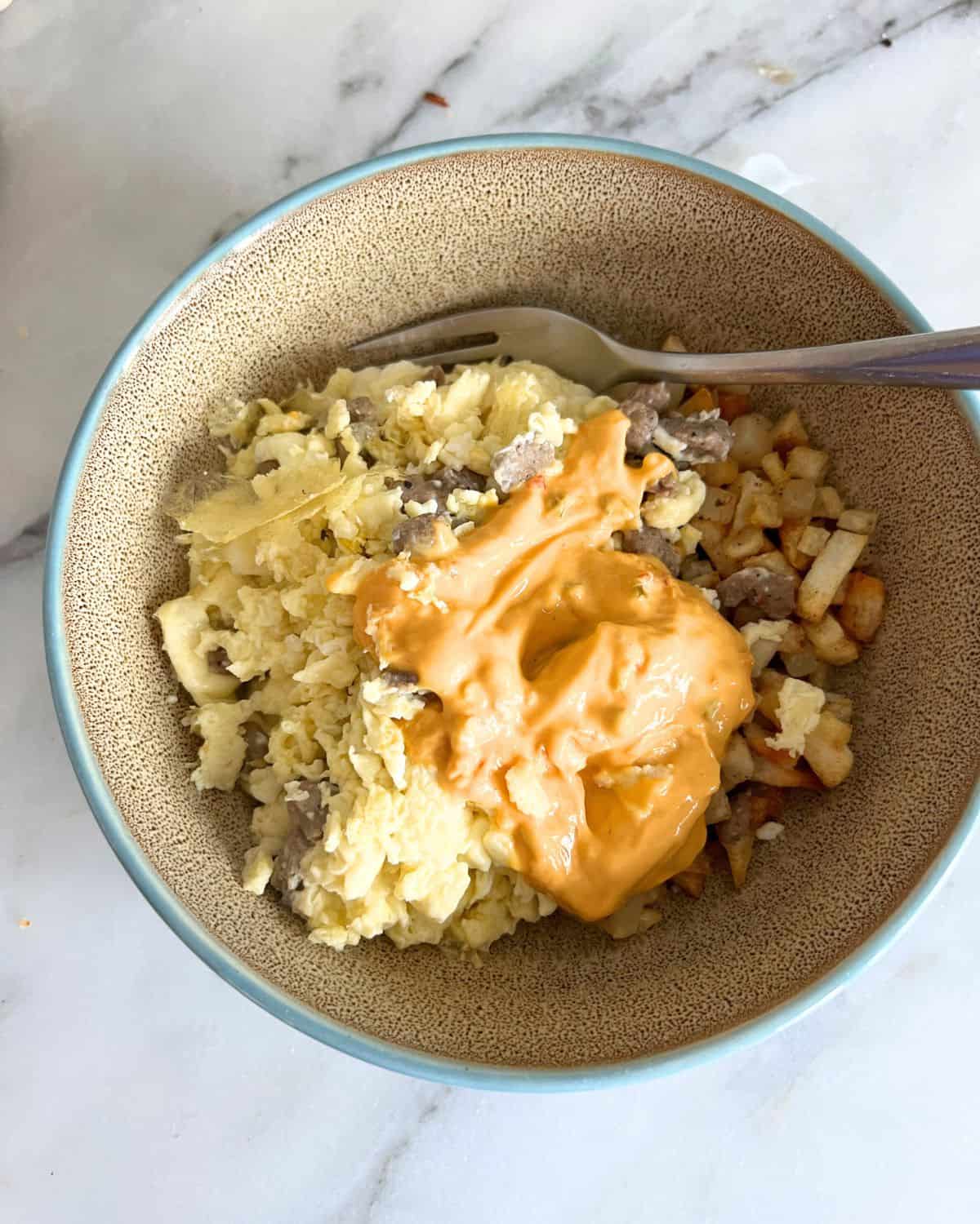 Air fryer breakfast bowls in a brown plate with a fork. 