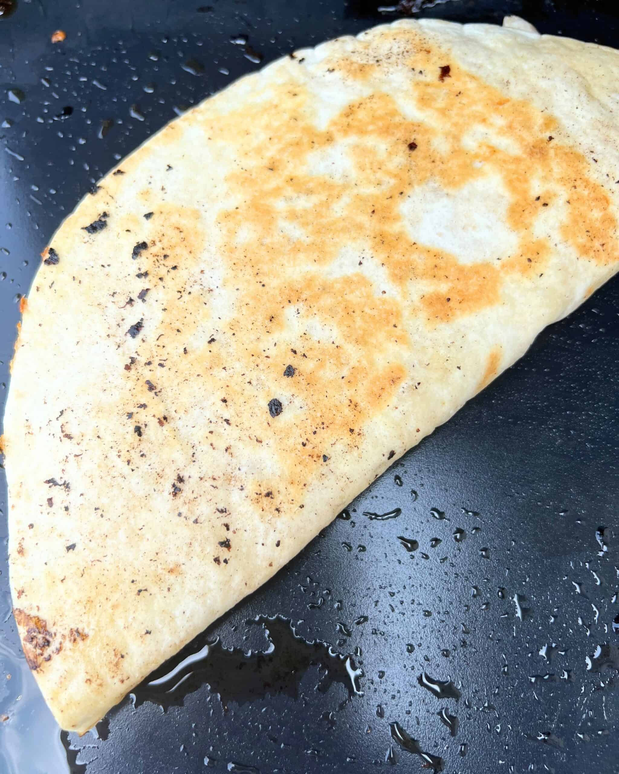 Grilled chicken quesadilla finished on a griddle. 