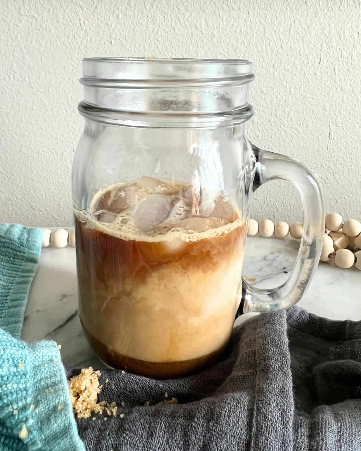 Ingredients for brown sugar shaken espresso poured in a jar.