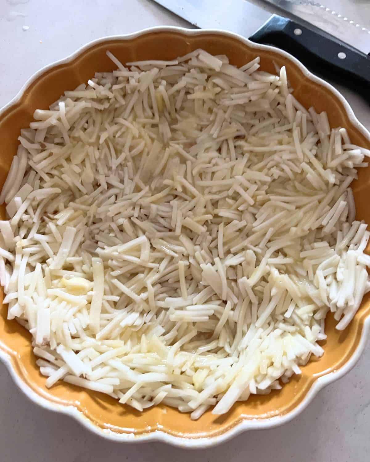 Hash browns crust in a pie dish. 