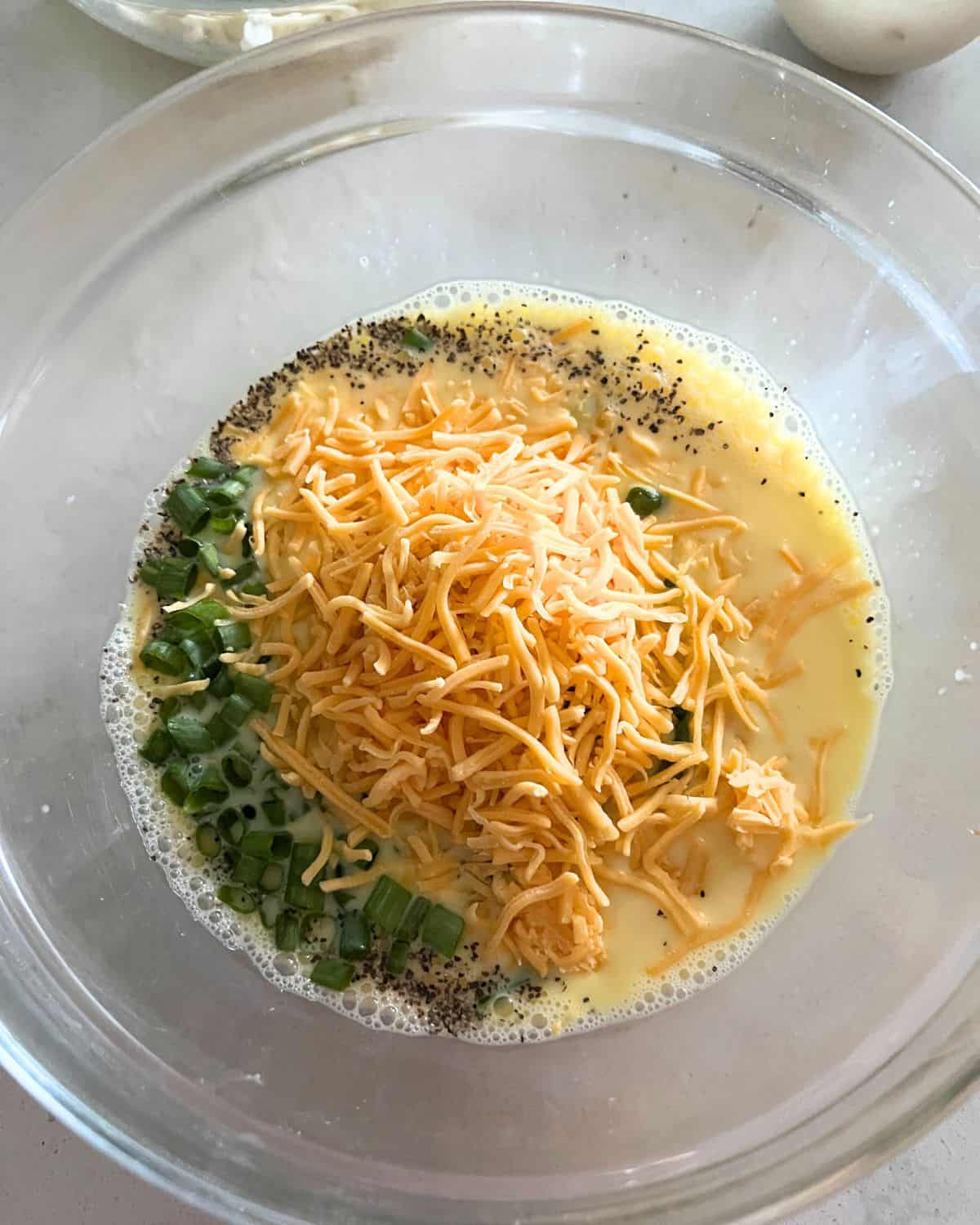 Eggs and hash brown quiche ingredients together in a bowl.