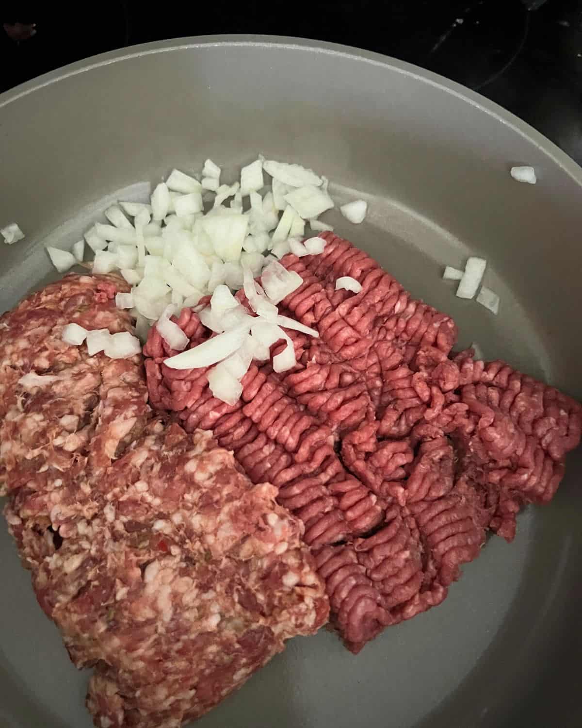 Beef and onions cooking on a skillet. 