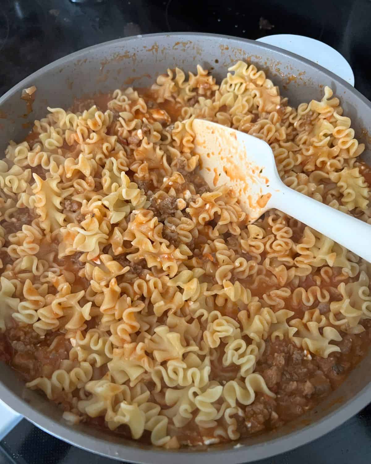 Noodles, beef, and cheese, in a skillet. 