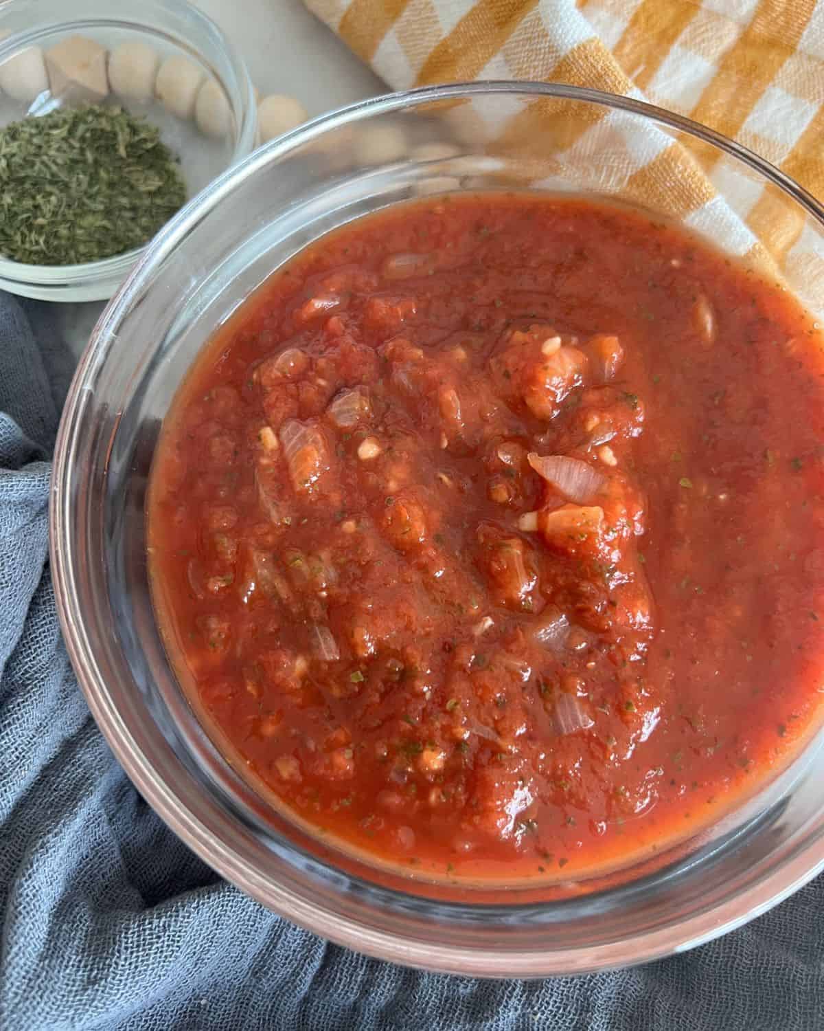 Finished marinara sauce together in a glass clear bowl.