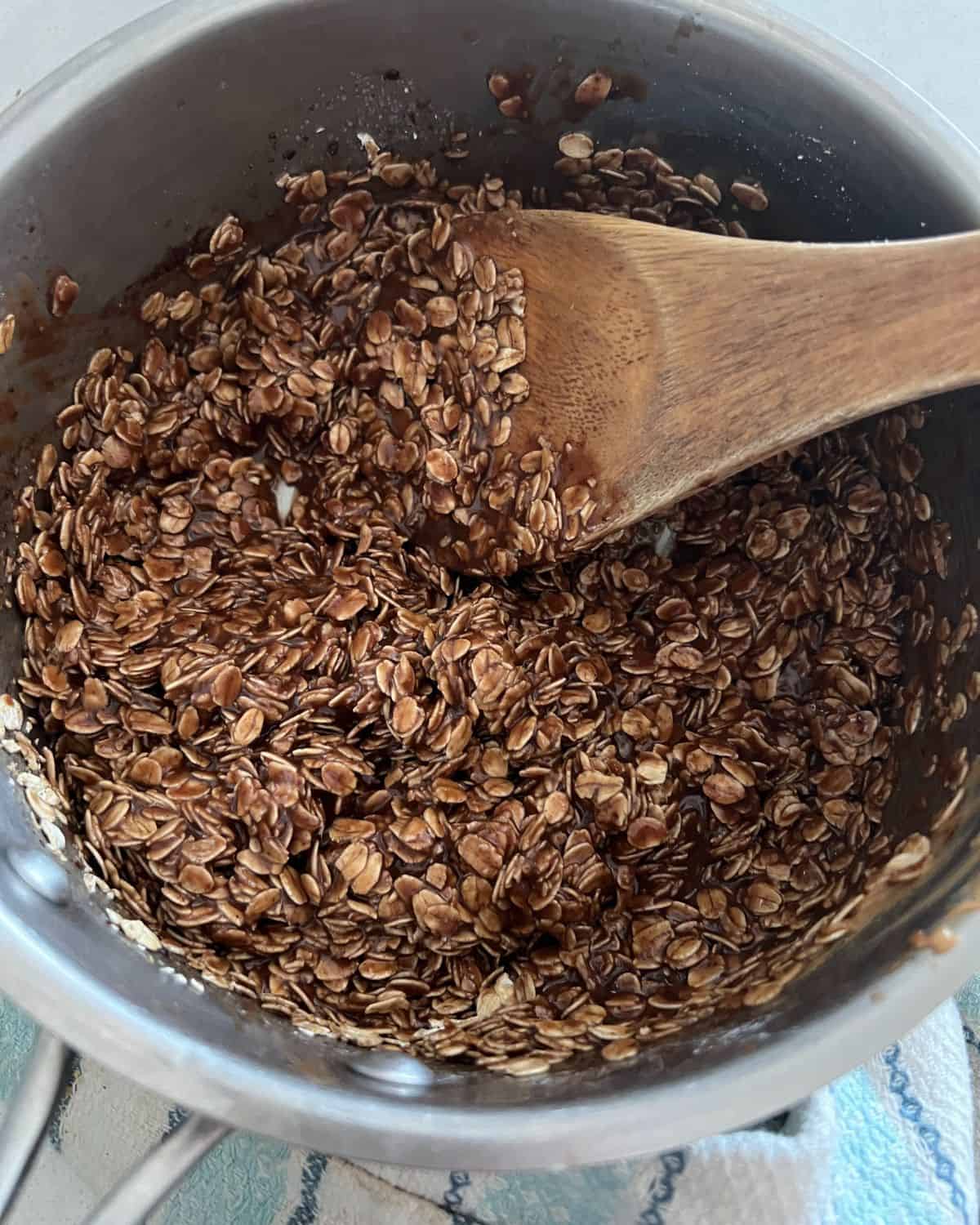 Oats, peanut butter, and chocolate combined in a pan. 