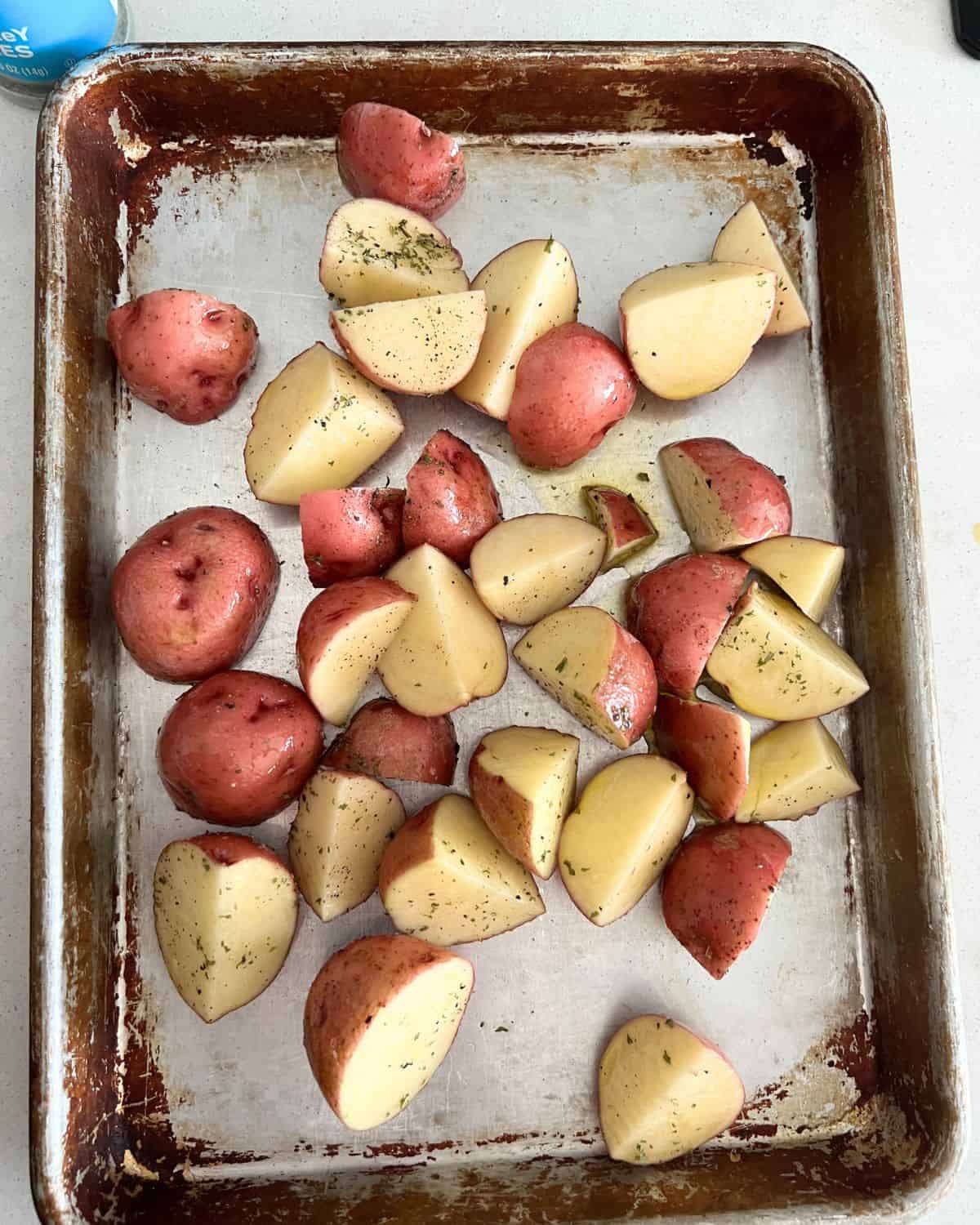 Seasoned potatoes on a sheet pan. 