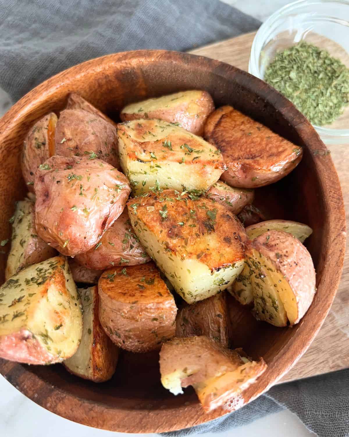 Roasted potatoes in a brown bowl. 