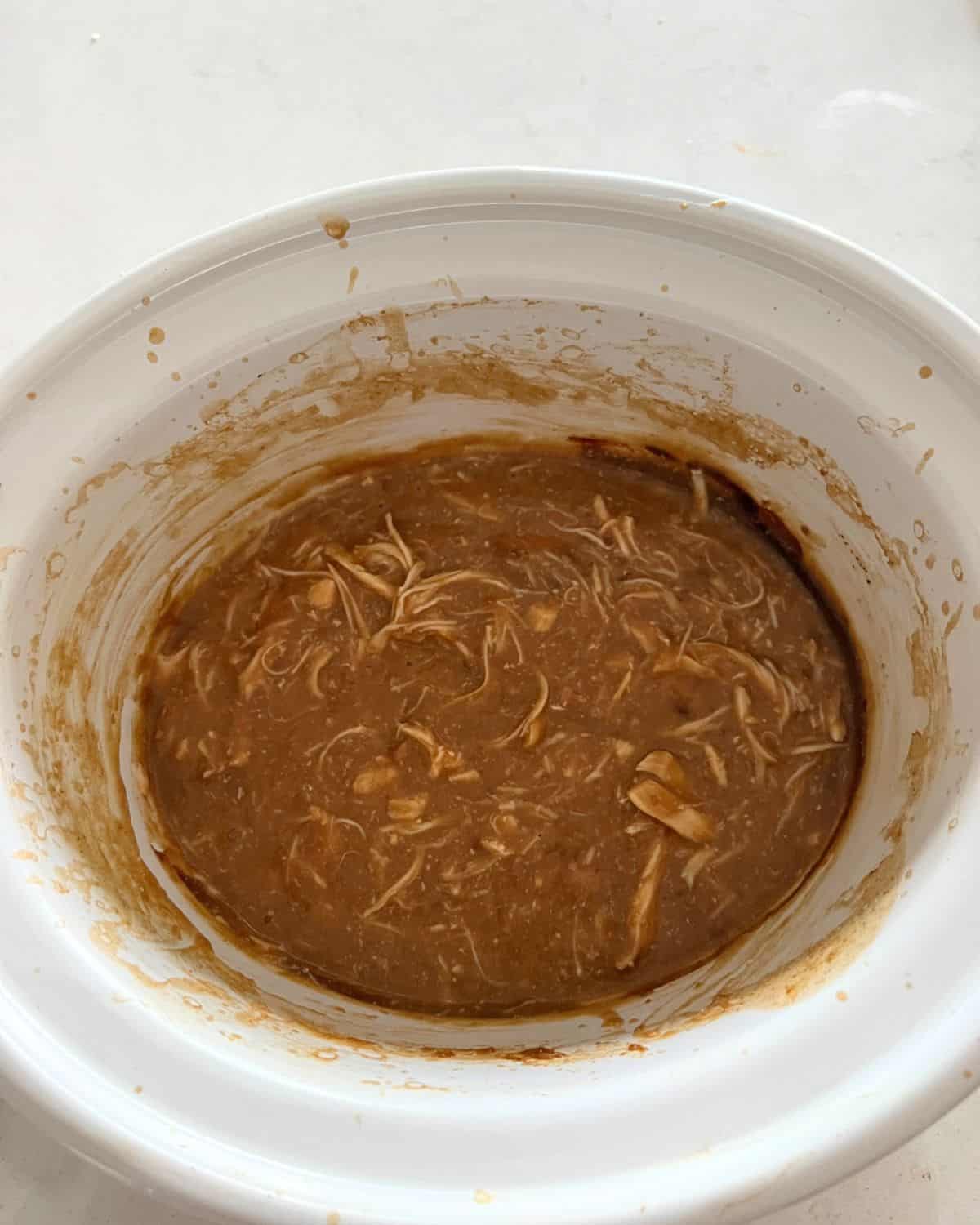Shredded chicken with gravy in crock pot. 